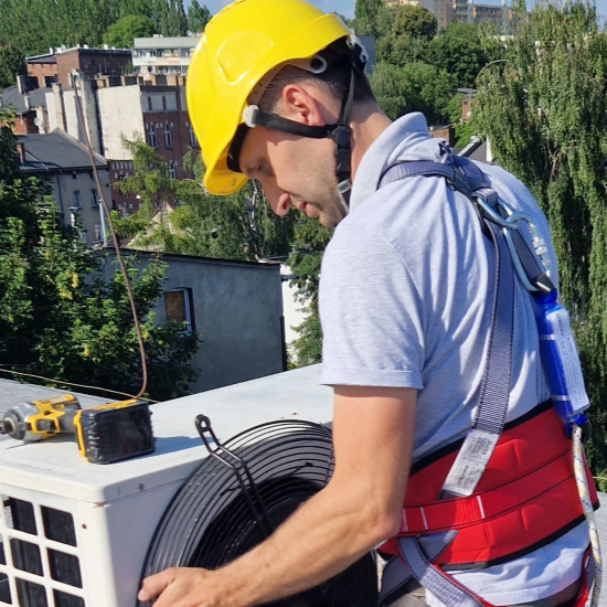 Instalator-montujący-jednostkę-zewnętrzną-na-dachu